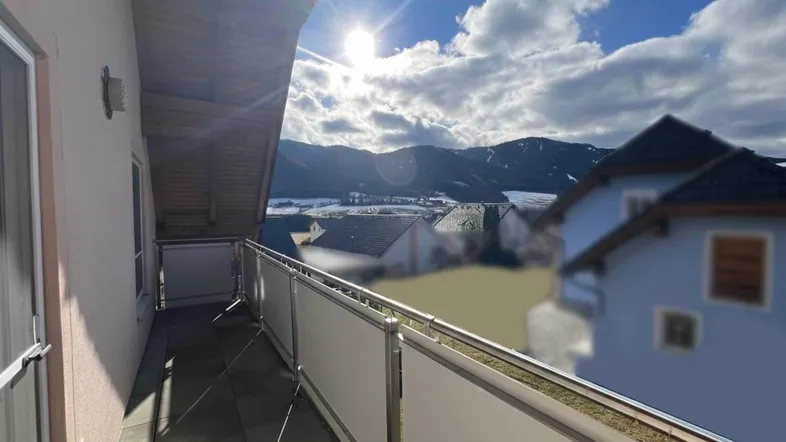 Sonniger Balkon mit moderner Glasbrüstung und weitem Blick auf die verschneiten Berge.