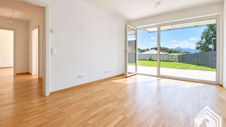 Helles Wohnzimmer mit Parkettboden und großzügigem Zugang zur Terrasse und Garten.