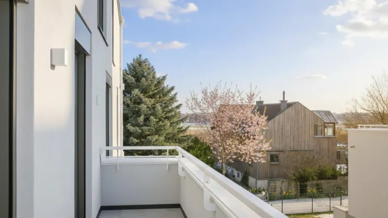 Moderner Balkon mit Fliesenboden und Blick auf die umliegende Nachbarschaft unter blauem Himmel.