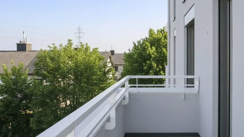 Heller Balkon mit modernen Fliesen und weißem Geländer, bietet Blick auf die Umgebung.