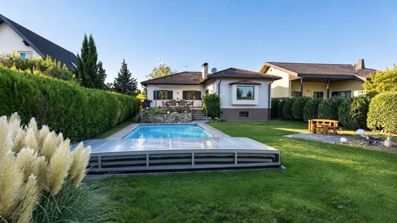 Großzügiger Gartenbereich mit privatem Swimmingpool und gepflegter Rasenfläche hinter dem Haus.
