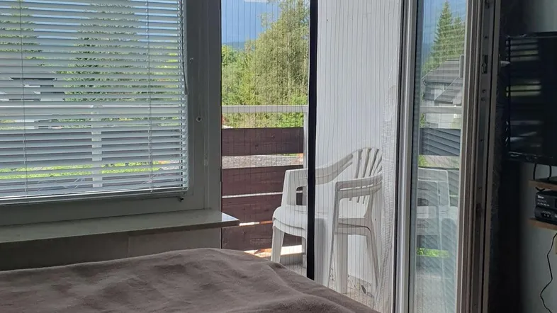 Schlafzimmer mit Zugang zum Balkon und weitem Blick auf die umliegende Berglandschaft.