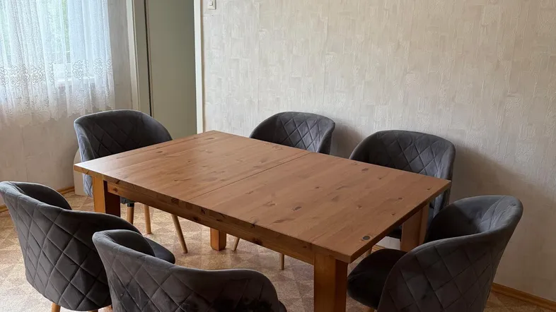 Heller Essbereich mit einem Holztisch und sechs bequemen grauen Stühlen, ideal für Familienmahlzeiten.