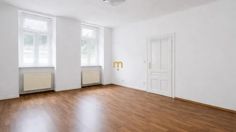 Helles, leeres Zimmer mit Laminatboden und zwei großen Fenstern, bereit zur individuellen Gestaltung.