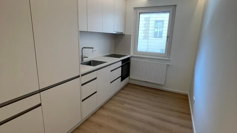 Moderne Einbauküche in Weiß mit integrierten Geräten und indirekter Beleuchtung, ideal für effizientes Kochen.