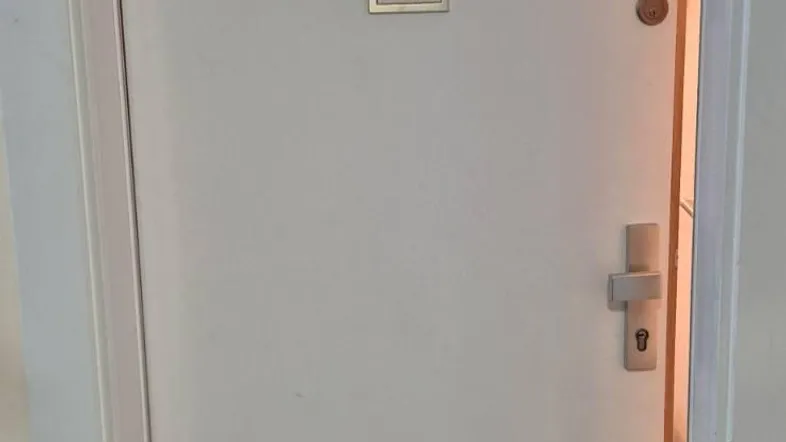 Weiße Wohnungstür mit der Nummer 32 in einem hellen Flur, der den Eingangsbereich zeigt.