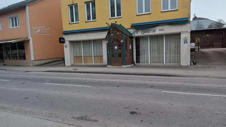Gelbes Gebäude mit mehreren Fenstern und einem markanten Eingangsbereich, direkt an einer Straße gelegen.