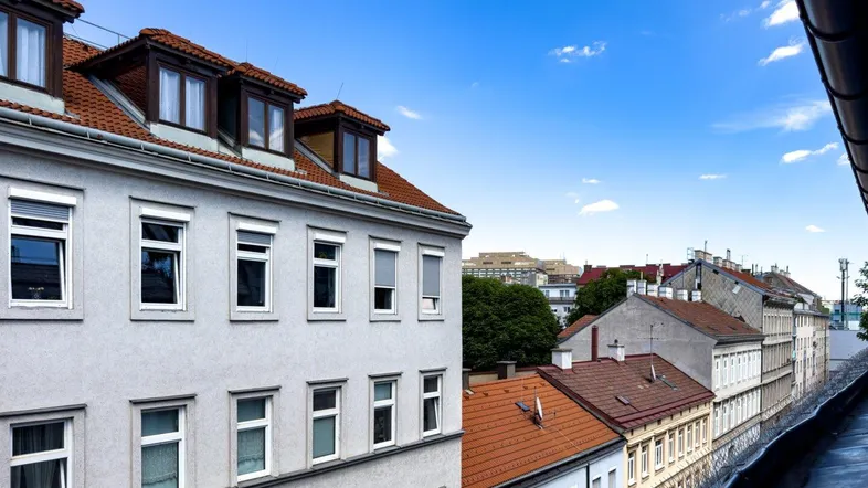 Blick über die Dächer der Stadt mit traditionellen Gebäuden und blauem Himmel.