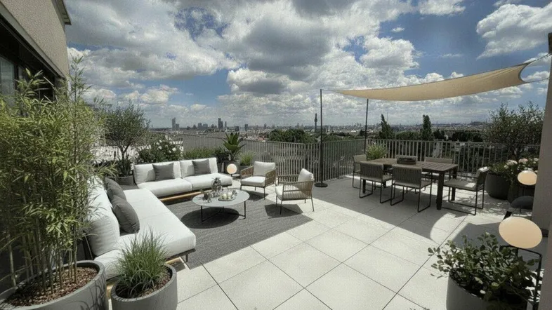 Große möblierte Dachterrasse mit Lounge-Bereich, Essplatz und weitem Blick über die Stadt.