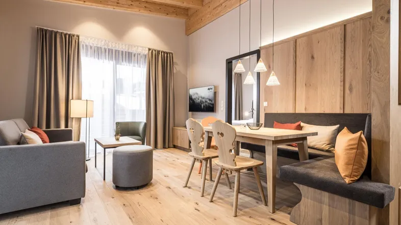 Helles Wohn- und Esszimmer mit Holzböden, modernen Möbeln und großen Fenstern.