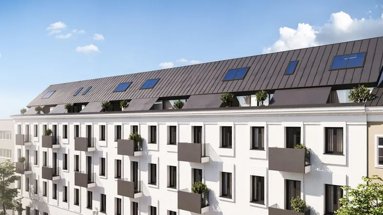 Moderne Gebäudefassade mit weißen Wänden, dunklem Dach und kleinen Balkonen unter blauem Himmel.