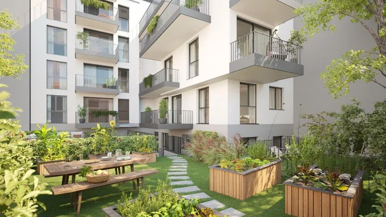 Moderne Wohnanlage mit Gemeinschaftsgarten, Hochbeeten und Sitzbereich im Freien.