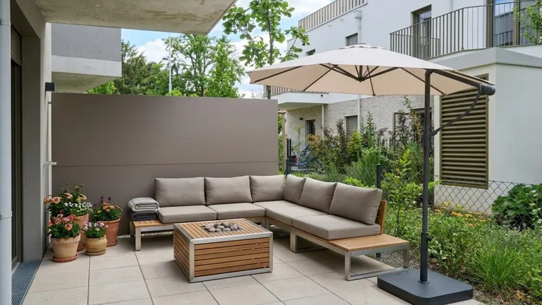 Gemütliche Terrasse mit moderner Lounge-Sitzgruppe und Sonnenschirm, ideal zum Entspannen im Freien.