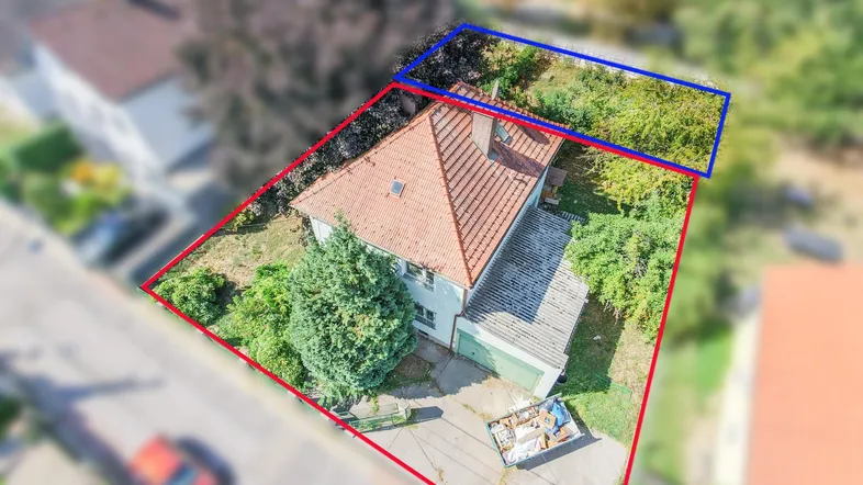 Luftaufnahme eines Einfamilienhauses mit angrenzendem Grundstück und umliegender Bebauung.
