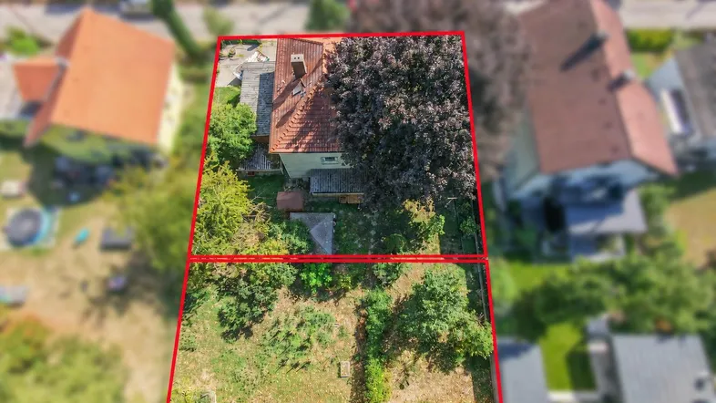 Luftaufnahme eines Hauses mit großem Grundstück, umrandet von roten Linien, in grüner Umgebung.