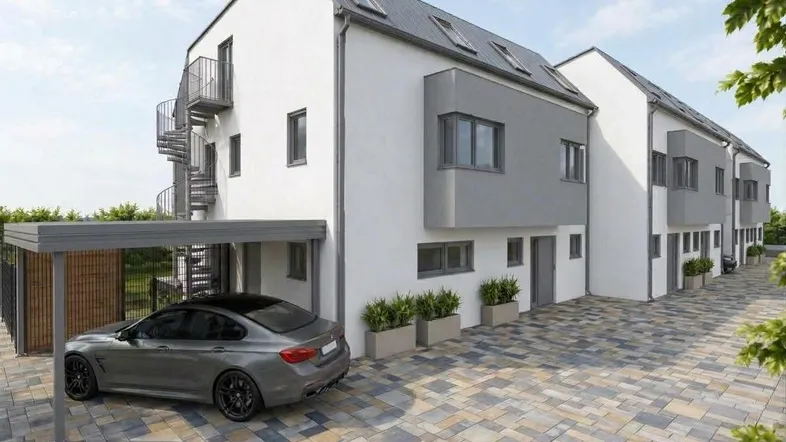 Moderne Reihenhausfassade mit Carport, gepflasterter Einfahrt und Außentreppe an der Seite.