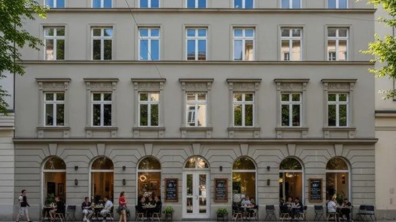 Historisches Gebäude mit klassischer Fassade, großen Fenstern und Geschäften im Erdgeschoss.