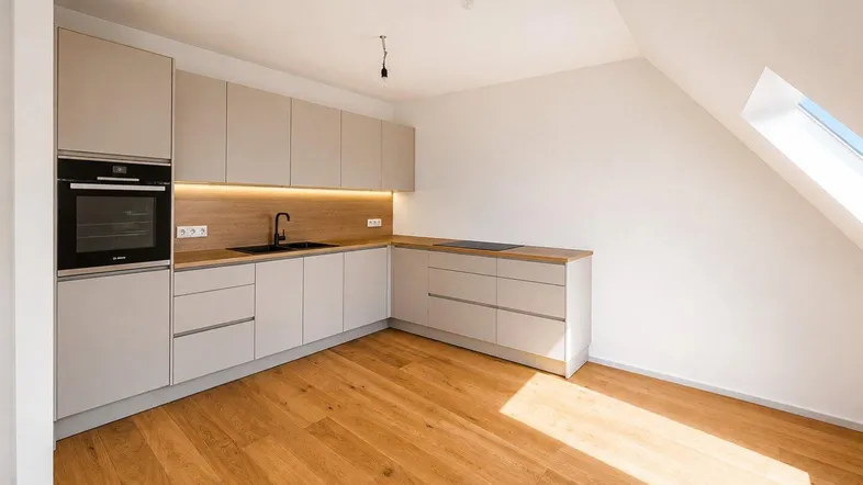 Moderne Küche mit hellgrauen Schränken, Holzarbeitsplatte, Einbaugeräten und Dachfenster.