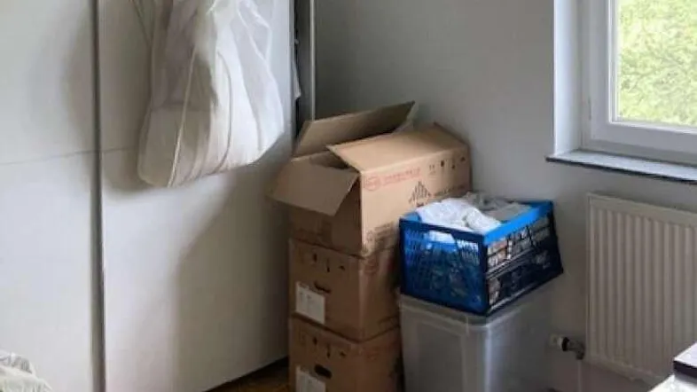 Helles Schlafzimmer mit Parkettboden, großem Kleiderschrank und Fenster mit Blick ins Grüne.
