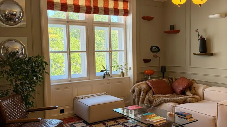Gemütliches Wohnzimmer mit Fischgrätparkett, Stuckdecke und stilvoller Beleuchtung.