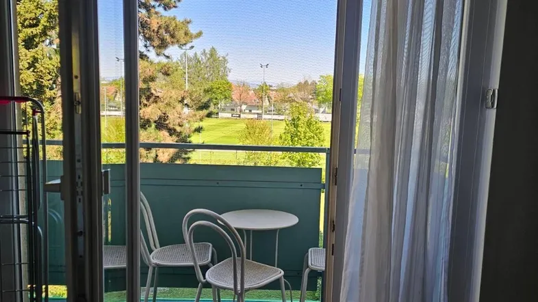 Heller Balkon mit Sitzgelegenheiten und weitem Blick ins Grüne.