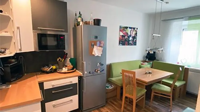 Gemütliche Wohnküche mit Essbereich, Holzfußboden und integrierten Geräten.