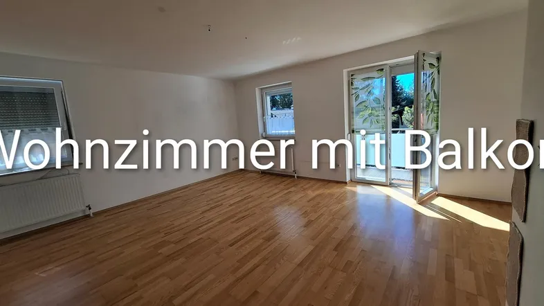 Helles Wohnzimmer mit Parkettboden und Zugang zum Balkon, ideal für entspannte Stunden.