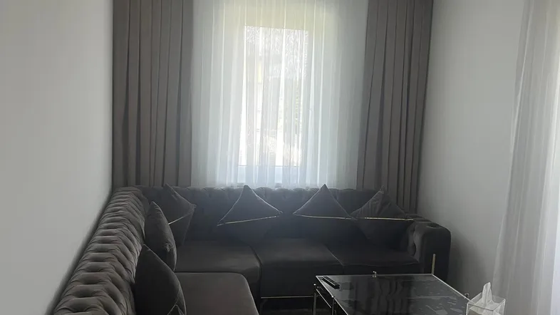Gemütliches Wohnzimmer mit großem Ecksofa, modernen Couchtischen und viel Tageslicht.