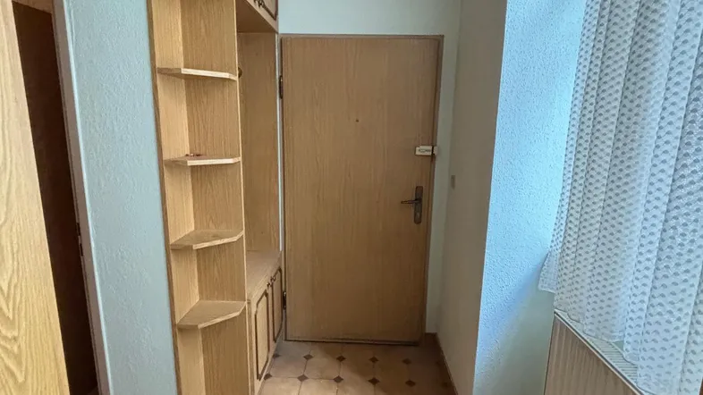 Eingangsbereich mit Holzdecke, Fliesenboden und integriertem Holzschrank in traditionellem Stil.