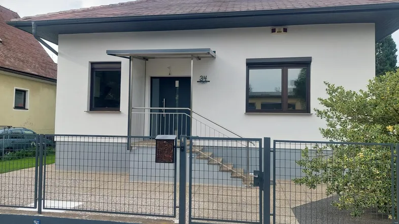 Vorderansicht des Hauses mit modernem Eingangsbereich und Vorgarten.