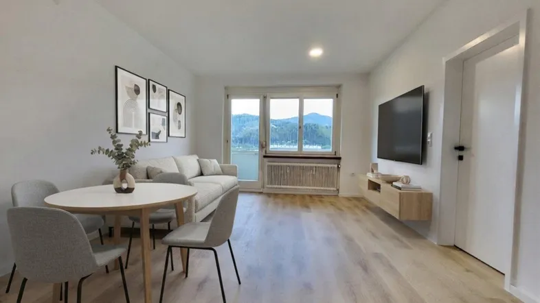Helles Wohn- und Esszimmer mit modernem Design, Holzboden und malerischem Bergblick.