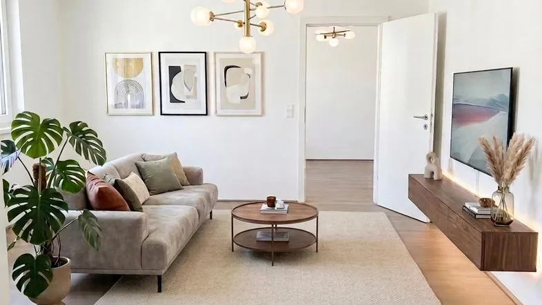 Helles Wohnzimmer mit modernem Sofa, Couchtisch und schwebendem TV-Möbel.