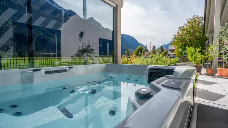 Außen-Whirlpool mit Bergblick und Glasabtrennung für entspannte Stunden im Freien.