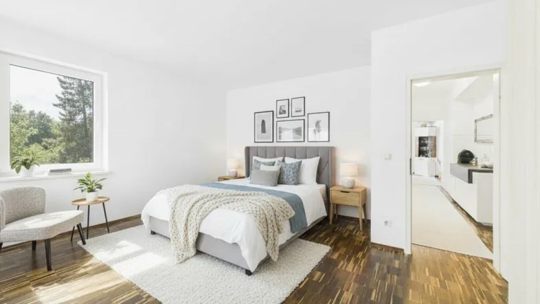 Helles Schlafzimmer mit Holzboden, großem Fenster und Blick ins Grüne, modern eingerichtet.
