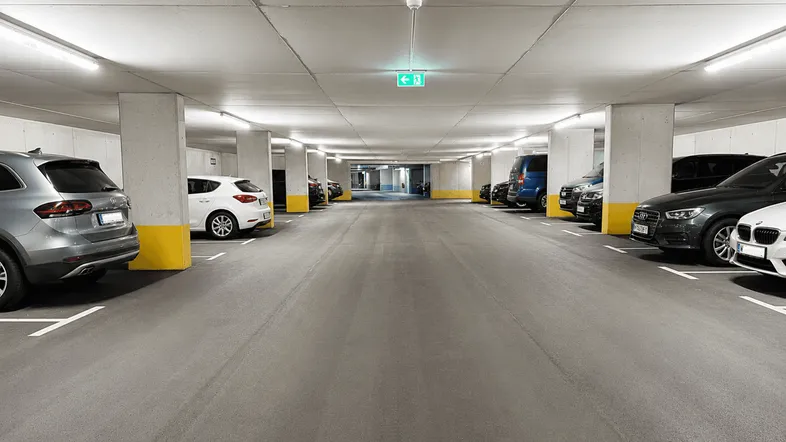 Geräumige Tiefgarage mit zahlreichen Parkplätzen, hell beleuchtet und gut organisiert für Bewohner.