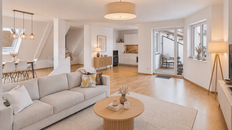 Helles und offenes Wohn-Esszimmer mit integrierter Küche, Parkettboden und Zugang zu einem kleinen Balkon.