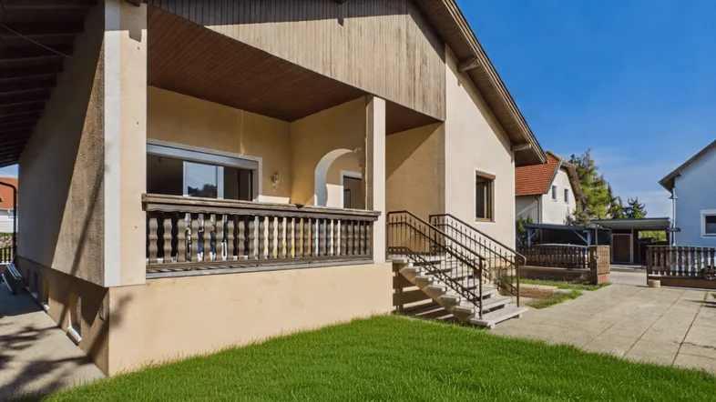 Gut erhaltenes Einfamilienhaus mit Balkon, gepflegtem Vorgarten und Zufahrt.