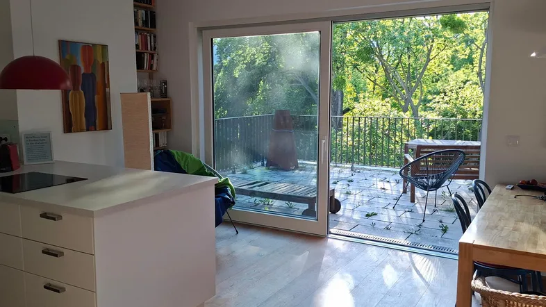 Helle Wohnküche mit Kochinsel, Essbereich und direktem Zugang zur sonnigen Terrasse.