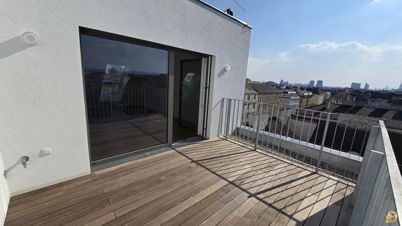 Geräumige Dachterrasse mit Holzboden, moderner Brüstung und weitem Blick über die Stadt.