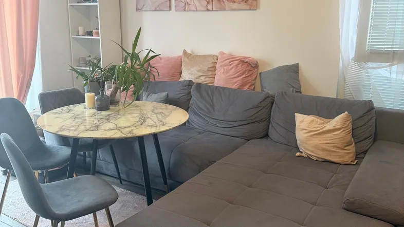 Gemütlicher Wohn- und Essbereich mit großem Ecksofa, modernem Esstisch und hellem Ambiente.