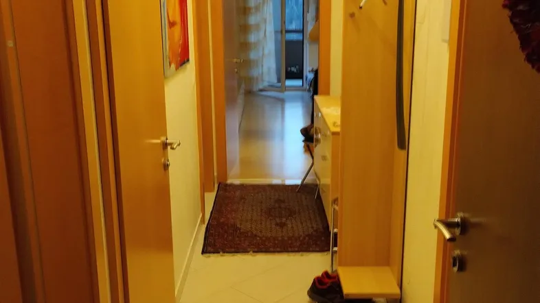 Heller Flur mit Fliesenboden und Garderobe, der zu weiteren Räumen führt.
