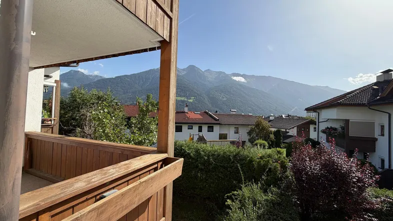 Geräumiger Balkon mit Holzverkleidung und herrlichem Blick auf die umliegende Berglandschaft.