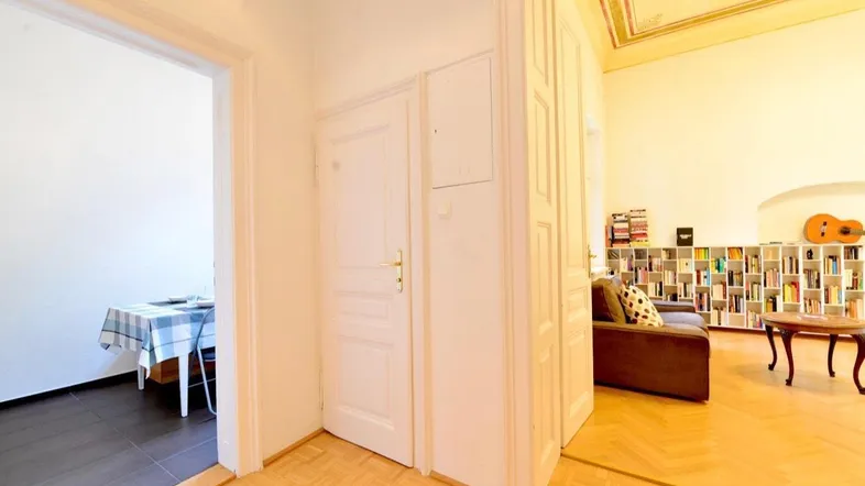 Heller Flur mit Parkettboden, der zu einem Wohn-/Schlafzimmer und einem Essbereich führt.