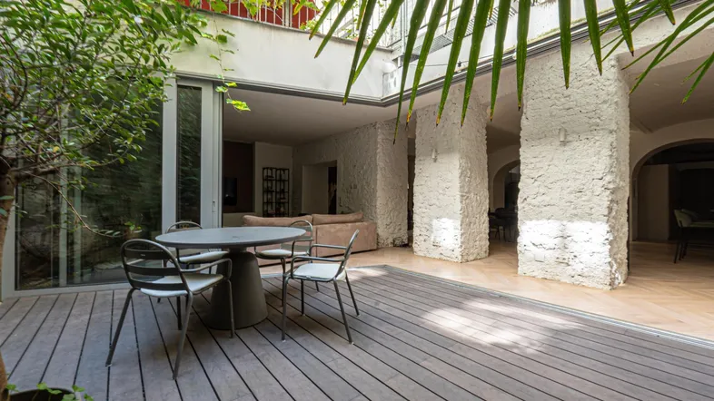 Große Terrasse mit Holzdeck, Gartenmöbeln und üppiger Bepflanzung, die zum Entspannen einlädt.