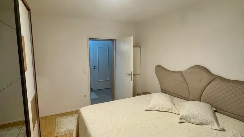 Schlafzimmer mit Doppelbett, Holzboden und einem modernen Einbauschrank.