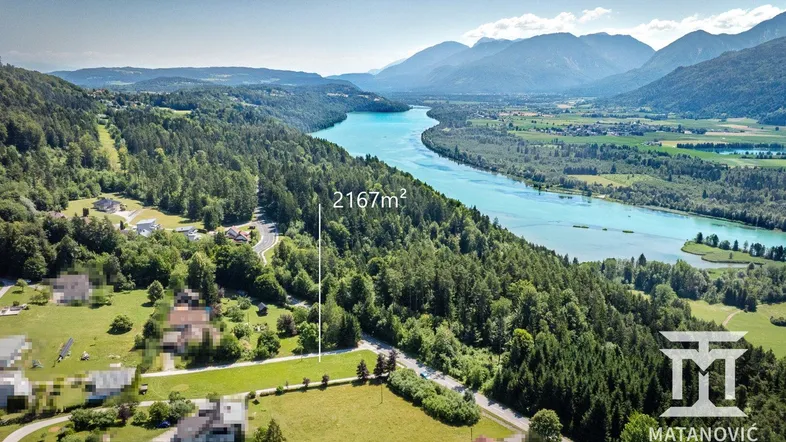 Panoramablick aus der Vogelperspektive auf eine weite Landschaft mit Fluss, Wäldern und Bergen.