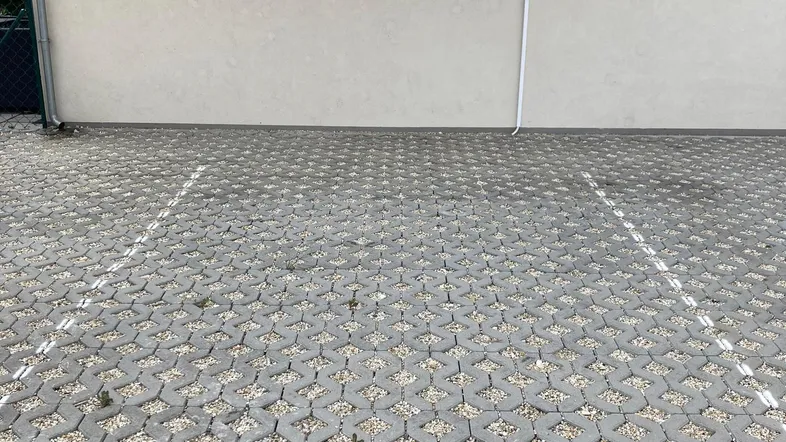 Parkplatz mit Pflastersteinen und Klimaanlage an der modernen Fassade des Gebäudes.