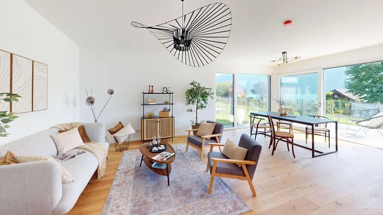 Helles, offenes Wohn-Esszimmer mit Holzboden, modernen Möbeln und großen Fenstern zum Garten.