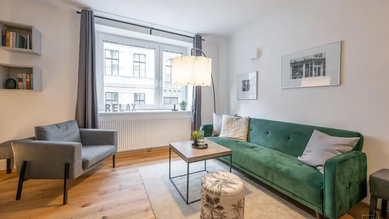 Helles Wohnzimmer mit modernem Sofa, Holzboden und Blick auf die Stadt durch das Fenster.