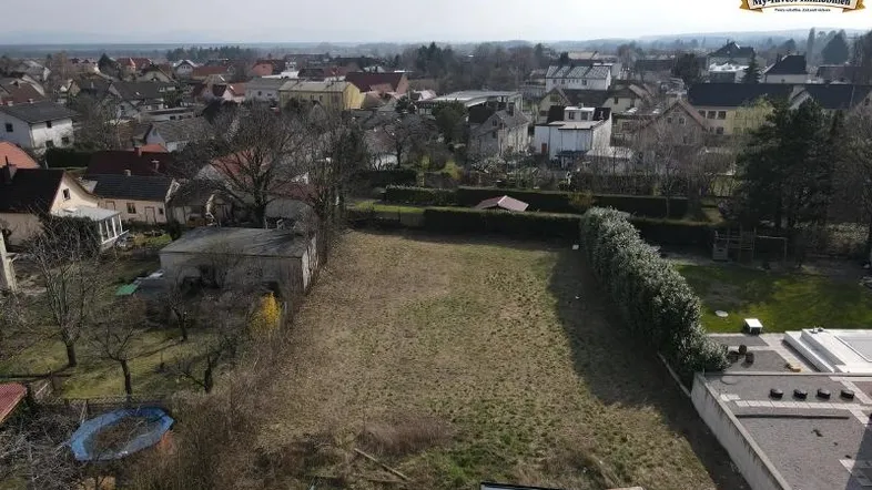 Luftaufnahme eines unbebauten Grundstücks in einer Wohngegend mit Blick auf die umliegende Bebauung.